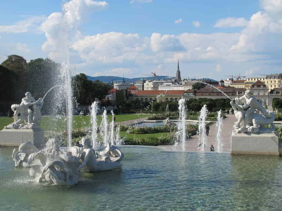 Verschnörkelte Brunnen im Wiener Garten mit Blick auf das Stadtbild.