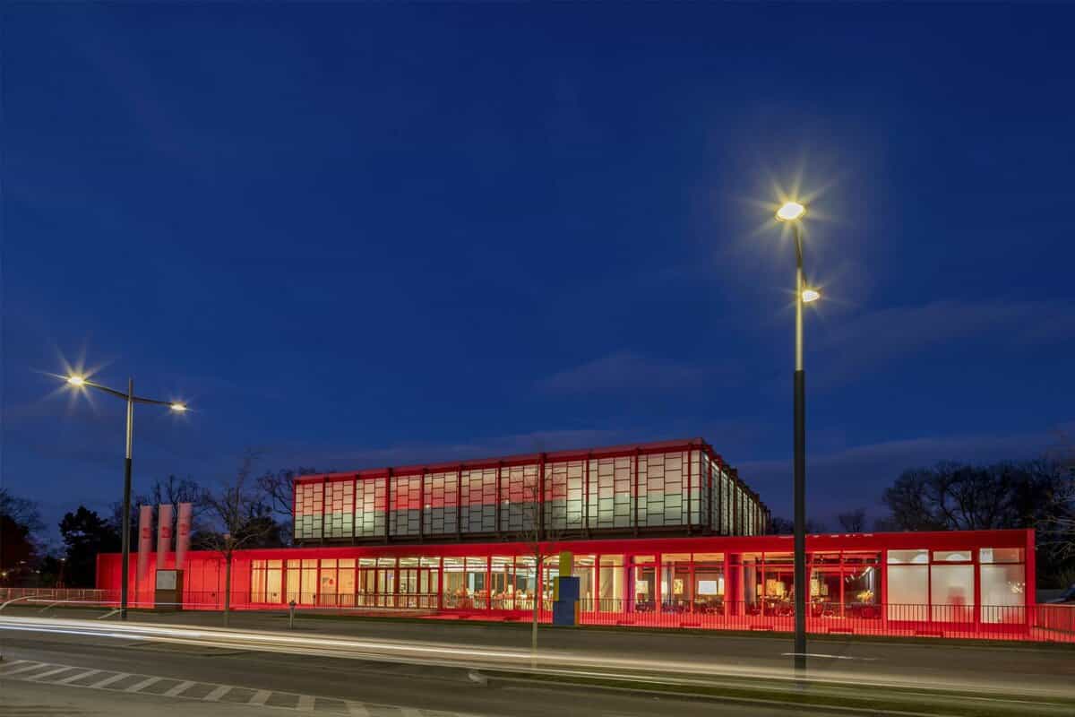 Red building illuminated at night, street view